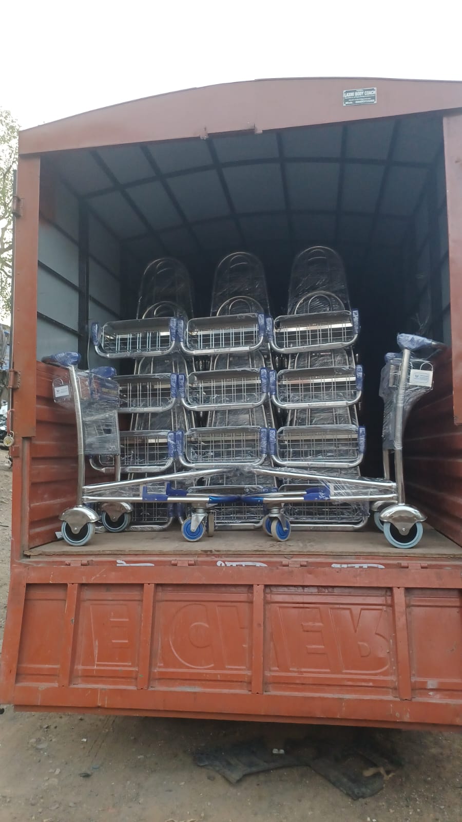 Airport trolleys wrapped and stacked inside open delivery truck